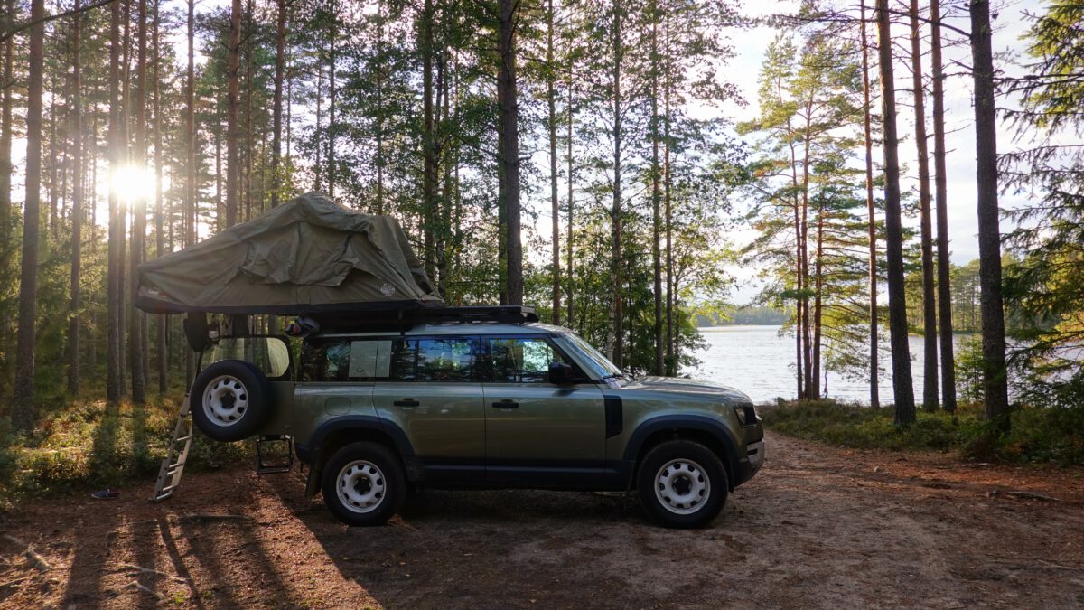 Defender-Camping in Sweden: Land Rover Defender with rooftoptent at a lake in Sweden
