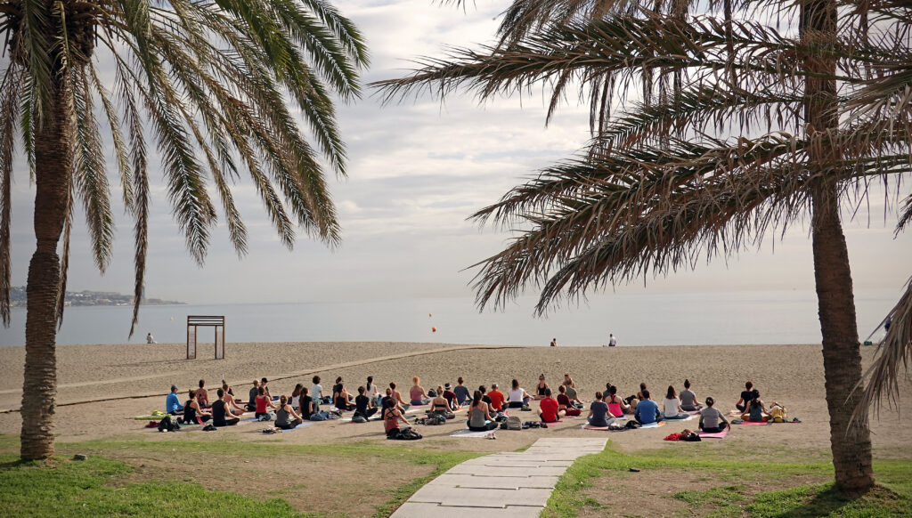 Yogagruppe am Strand von Malaga, Spanien.