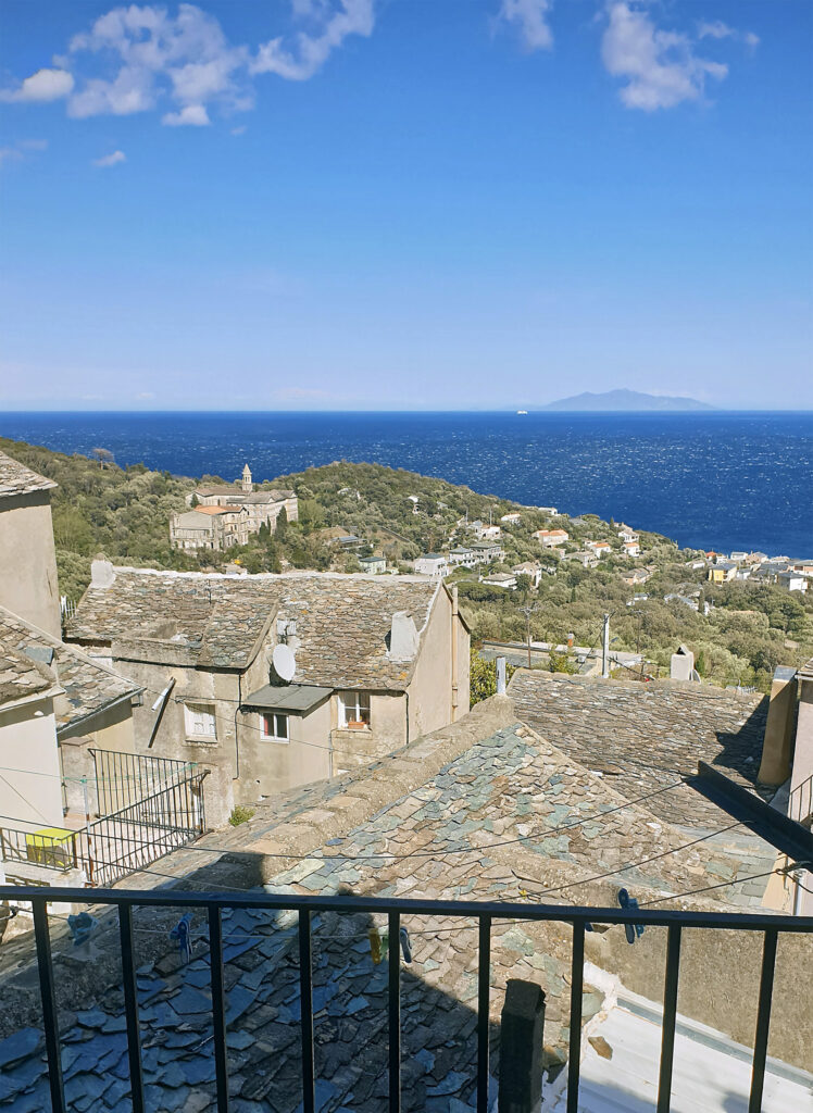 Rundreise über Korsika im Frühling: Blick über die Dächer des dorfes Erbalunga zum Meer